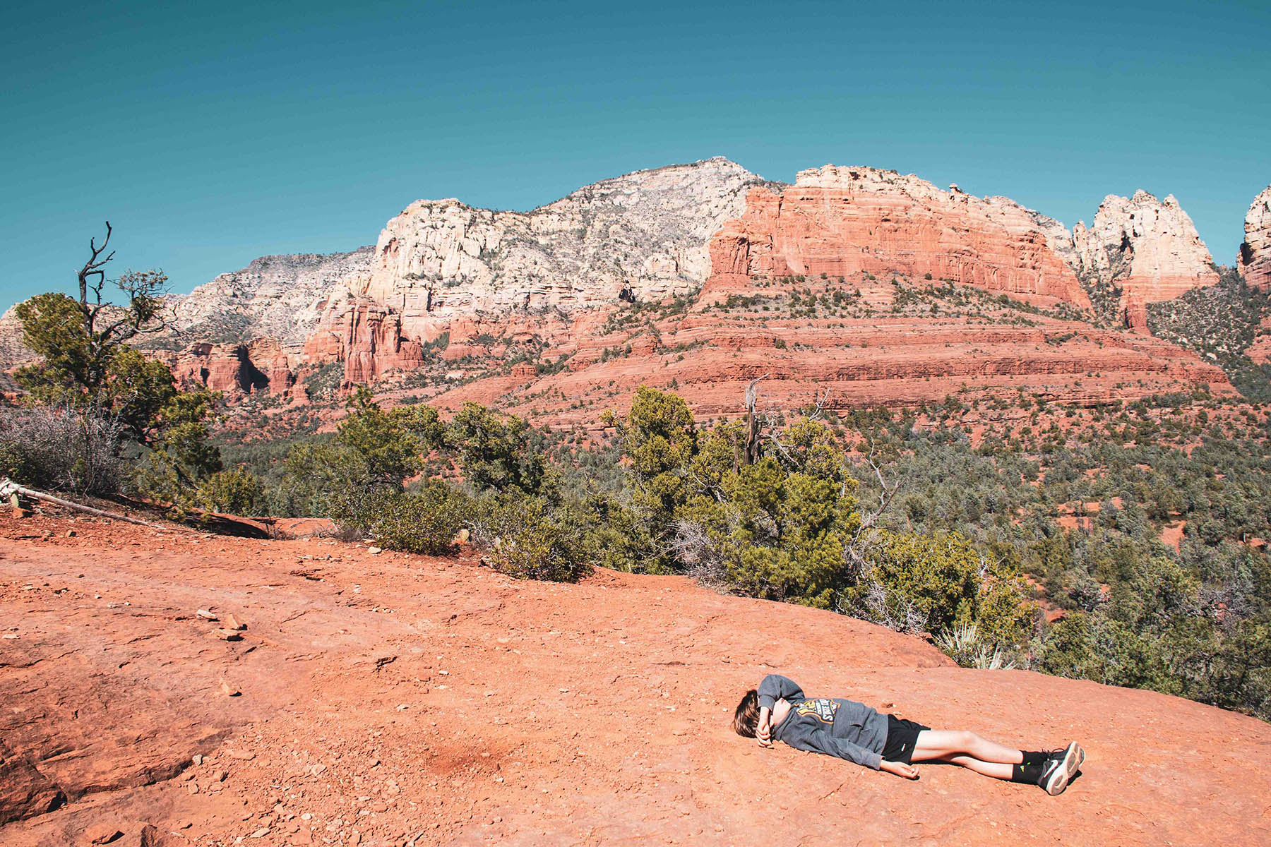 Photo of a young hiker laying down on the trail